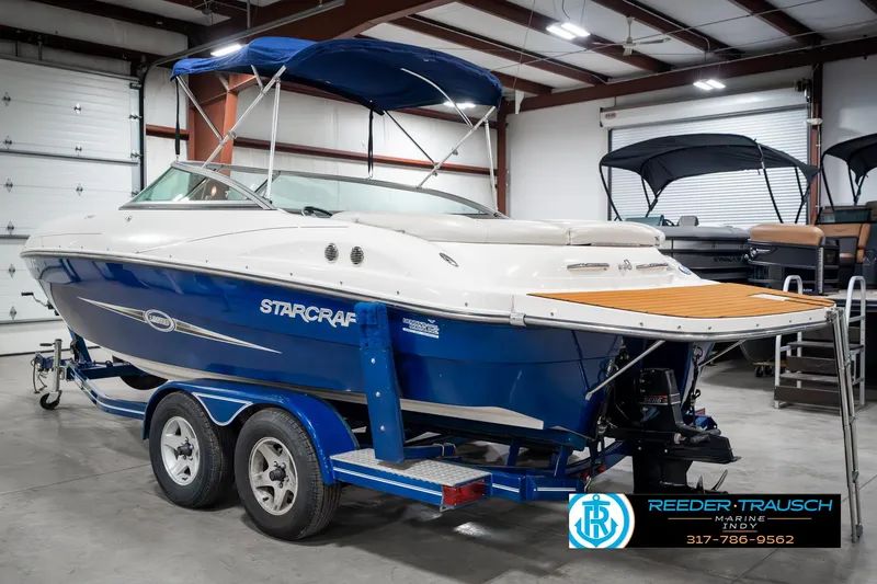 Slide: The Image of 2007 Starcraft Limited 1900 OB boat in showroom, blue and white design, on trailer. - 10