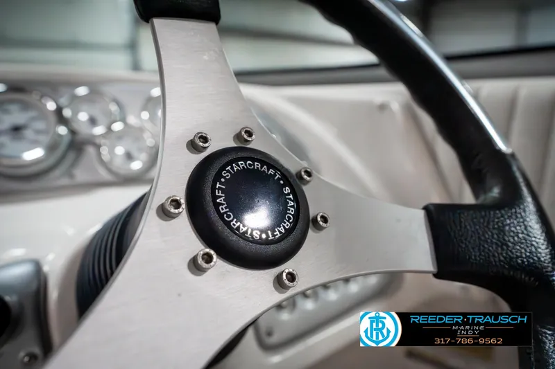 Slide: The Image of Steering wheel of 2007 Starcraft Limited 1900 OB boat, featuring brand logo and dashboard gauges. - 34
