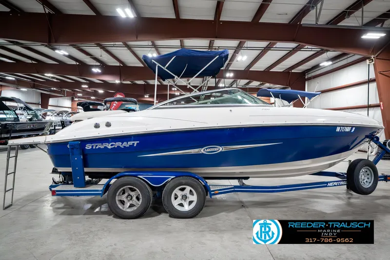 Slide: The Image of 2007 Starcraft Limited 1900 OB boat in showroom, blue and white design, on trailer. - 7