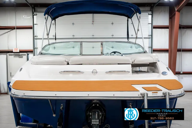 Slide: The Image of 2007 Starcraft Limited 1900 OB boat in a showroom, featuring a blue canopy and wooden deck. - 9