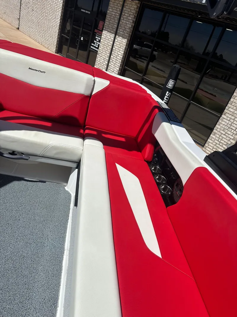 Slide: The Image of 2023 MasterCraft NXT22 boat interior with red and white seating. - 12