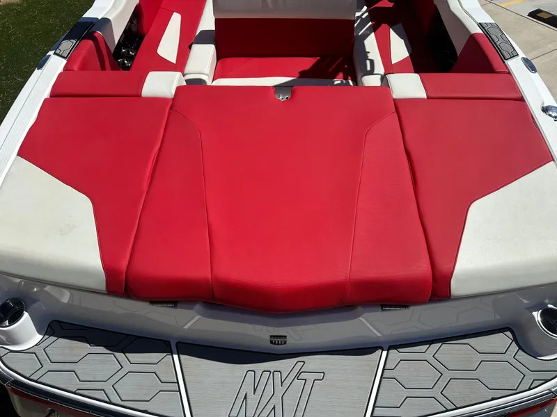 Slide: The Image of 2023 MasterCraft NXT22 boat with red and white seating, showcasing sleek design. - 16