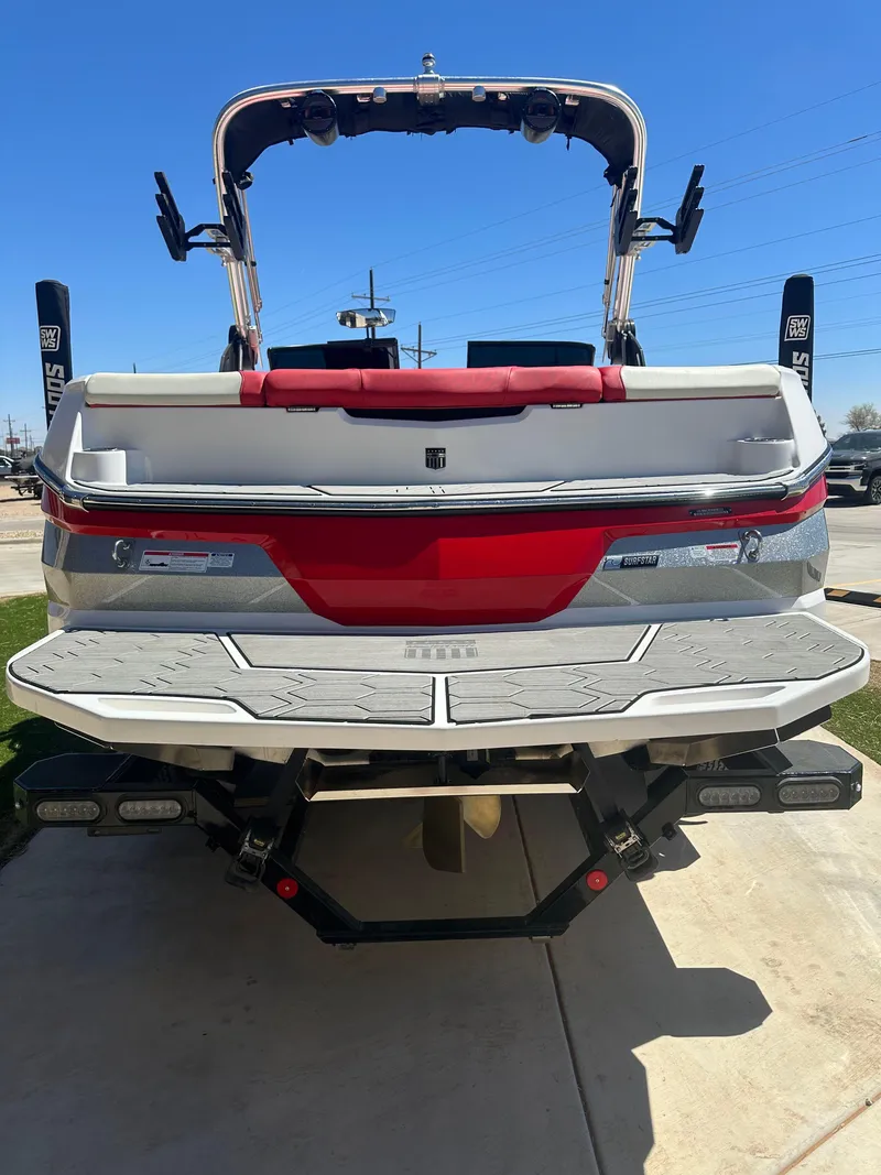 Slide: The Image of 2023 MasterCraft NXT22 boat, rear view, showcasing sleek design and vibrant red accents. - 18
