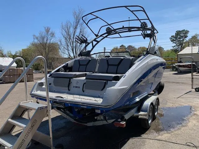 Slide: The Image of 2025 Yamaha Boats 255XD on trailer, rear view, with wakeboard tower and seating. - 16