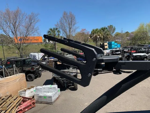 Slide: The Image of Wakeboard rack on 2025 Yamaha Boats 255XD, outdoor setting with vehicles and trees. - 7