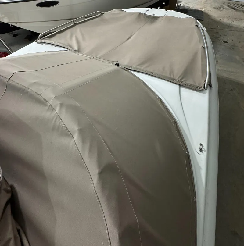 Slide: The Image of 2005 Crownline 240 EX boat with beige cover in storage. - 11