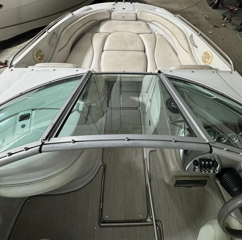 Slide: The Image of 2005 Crownline 240 EX boat interior with beige seating and glass windshield. - 13