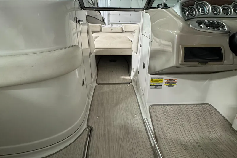 Slide: The Image of 2005 Crownline 240 EX boat interior with beige seating and dashboard controls. - 14