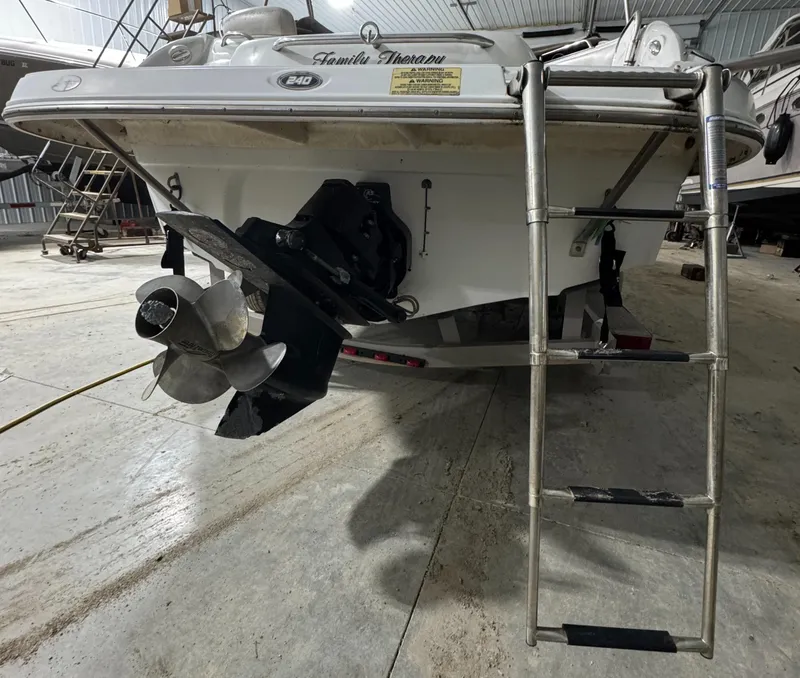 Slide: The Image of 2005 Crownline 240 EX boat with ladder and propeller in a storage facility. - 16