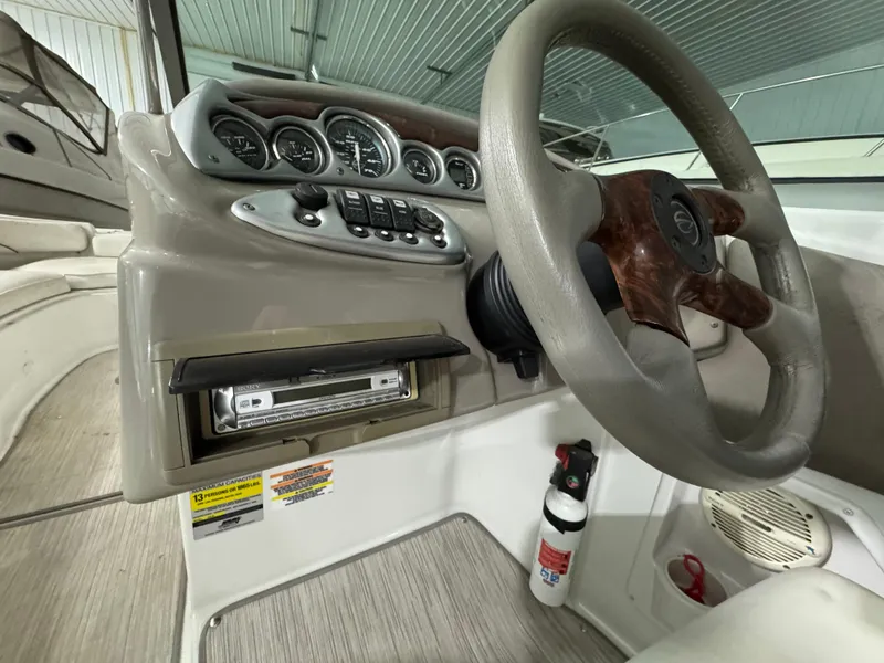 Slide: The Image of 2005 Crownline 240 EX boat dashboard with steering wheel and control panel. - 2