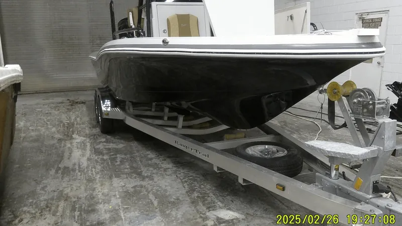 Slide: The Image of 2024 Ranger 2510 Bay boat on trailer in storage facility. - 10