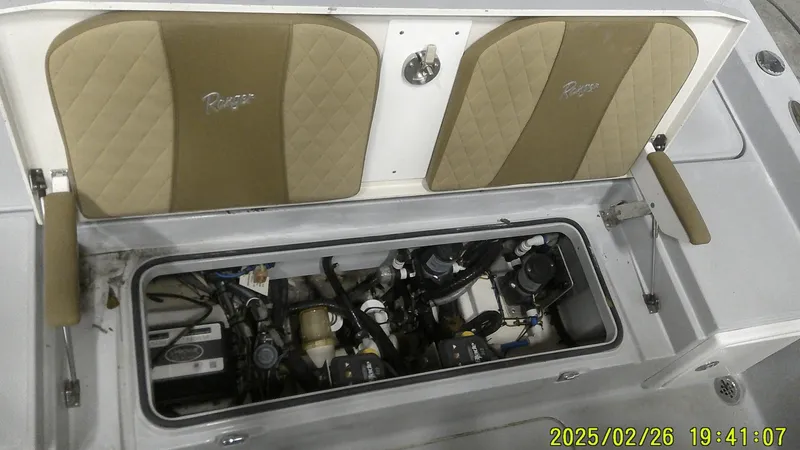 Slide: The Image of 2024 Ranger 2510 Bay boat engine compartment with open hatch, showcasing internal components. - 15