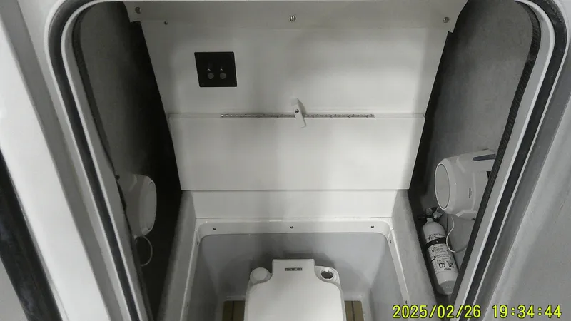 Slide: The Image of 2024 Ranger 2510 Bay boat interior with compact toilet and storage area. - 2