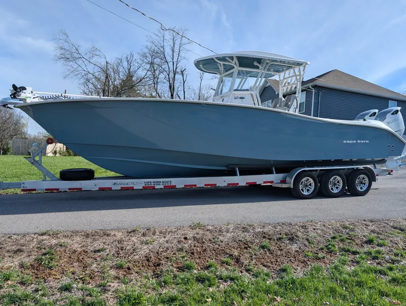 Slide: The Image of 2023 Cape Horn 32 XS boat on trailer, parked on a residential street. - 1