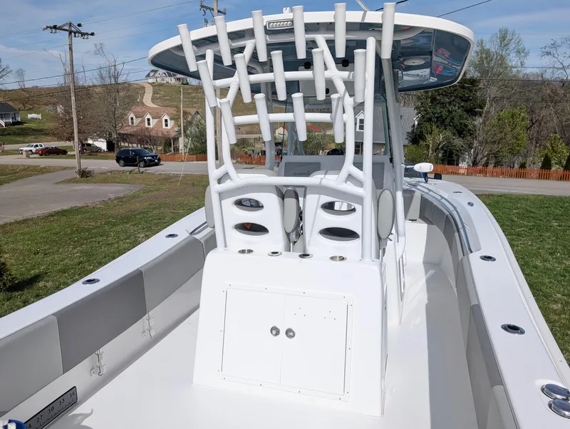 Slide: The Image of 2023 Cape Horn 32 XS boat with rod holders and spacious deck, parked outdoors. - 12