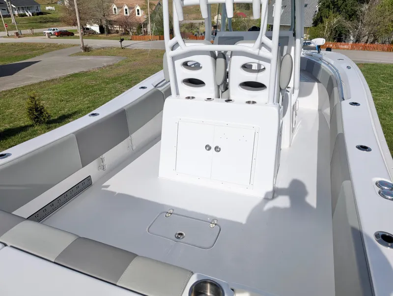 Slide: The Image of 2023 Cape Horn 32 XS boat deck with seating and storage, parked on grass. - 15