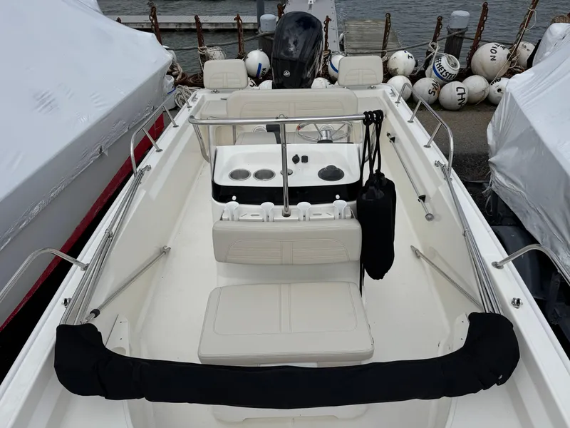 Slide: The Image of 2023 Boston Whaler 170 Montauk boat interior, docked with protective covers and buoys. - 10