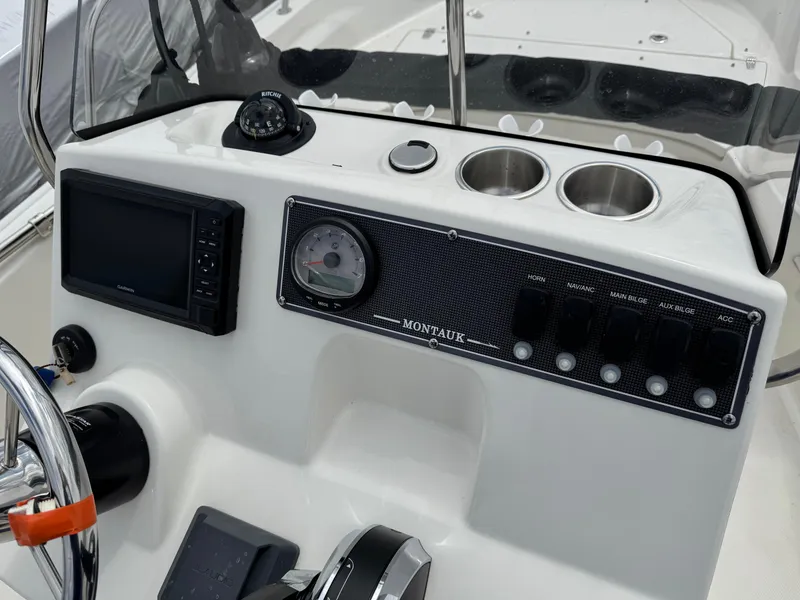 Slide: The Image of 2023 Boston Whaler 170 Montauk dashboard with controls and navigation display. - 13