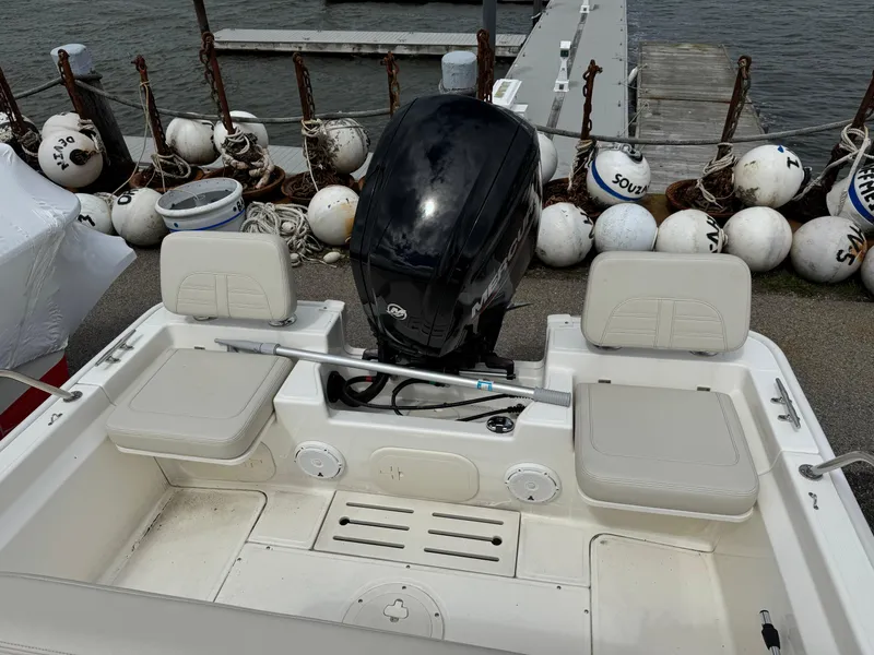 Slide: The Image of 2023 Boston Whaler 170 Montauk boat at dock, featuring outboard motor and seating. - 14