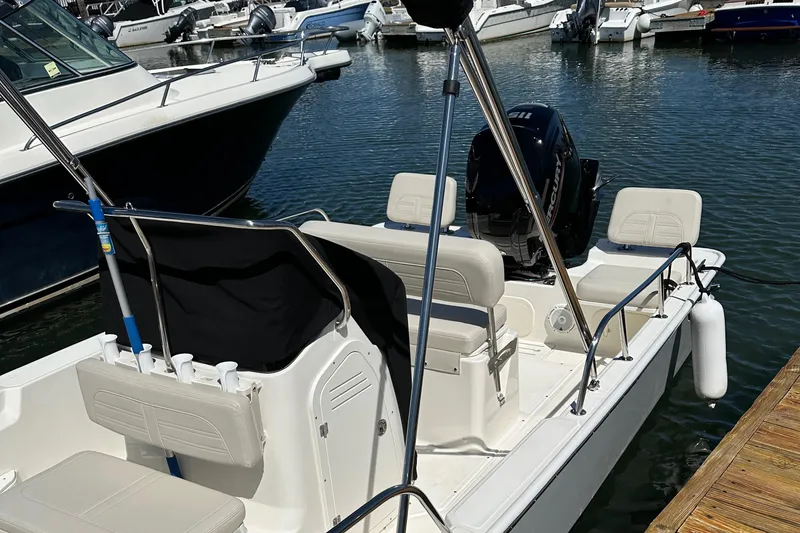 Slide: The Image of 2023 Boston Whaler 170 Montauk boat docked in marina, featuring seating and motor. - 15