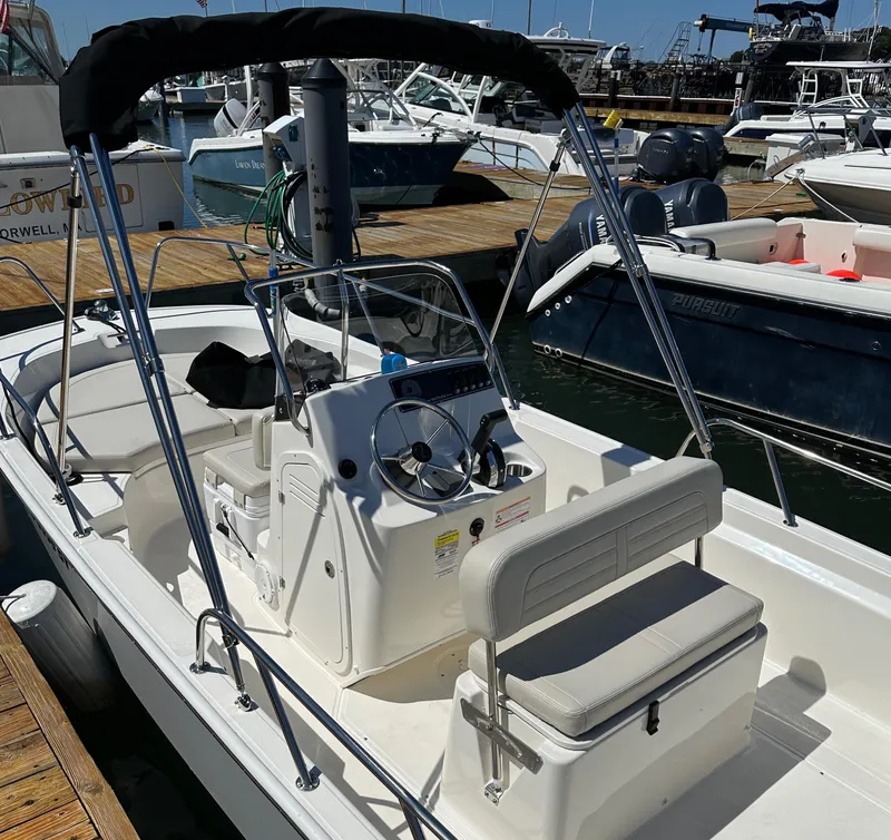 Slide: The Image of 2023 Boston Whaler 170 Montauk boat docked at marina, featuring center console and seating. - 17