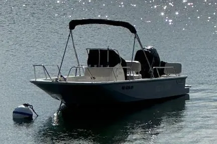Slide: The Image of 2023 Boston Whaler 170 Montauk boat floating on calm water with sunlight reflections. - 18