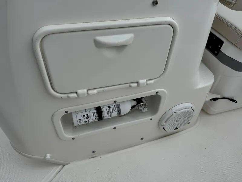 Slide: The Image of 2023 Boston Whaler 170 Montauk interior with storage compartment and fire extinguisher. - 25