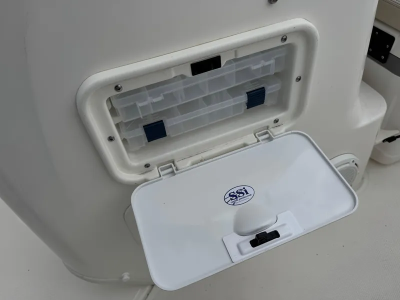 Slide: The Image of 2023 Boston Whaler 170 Montauk storage compartment with open lid and organizer tray. - 26