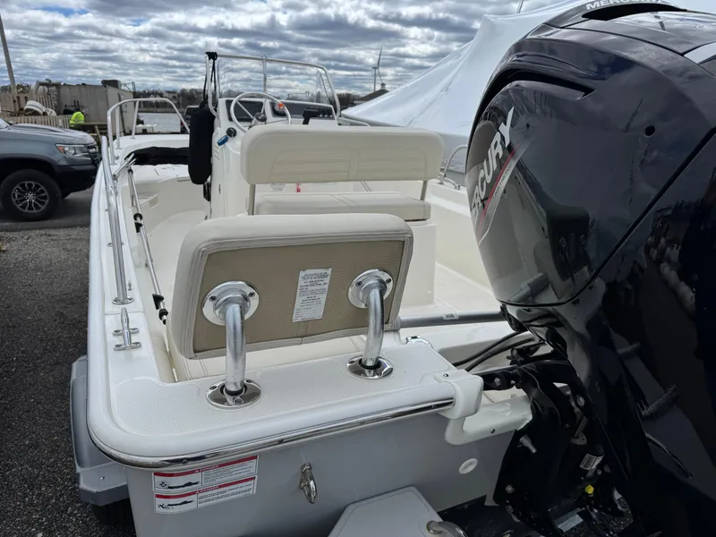 Slide: The Image of 2023 Boston Whaler 170 Montauk boat with Mercury engine, docked outdoors. - 3