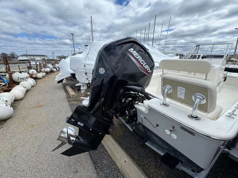 Slide: The Image of 2023 Boston Whaler 170 Montauk with Mercury outboard motor, docked under cloudy skies. - 6