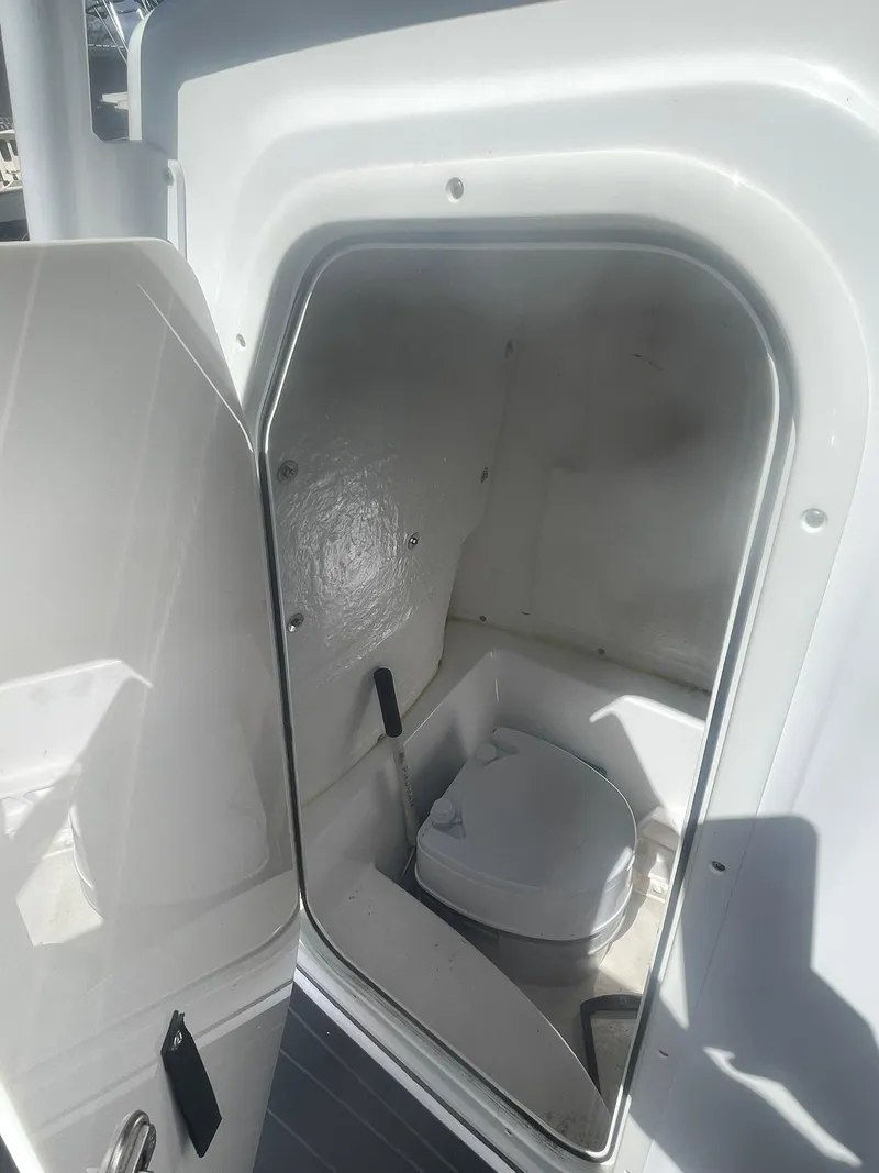Slide: The Image of 2022 Aquasport 2100 CC boat interior with compact marine toilet. - 19