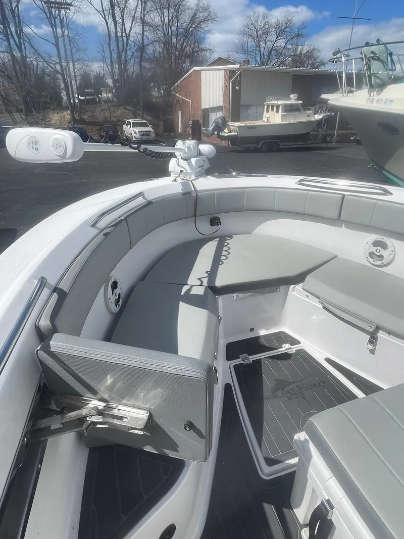 Slide: The Image of 2022 Aquasport 2100 CC boat interior with cushioned seating and storage compartments. - 23