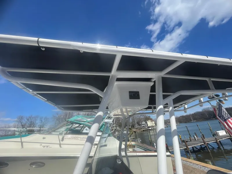 Slide: The Image of 2022 Aquasport 2100 CC boat with T-top, docked under clear blue sky. - 25