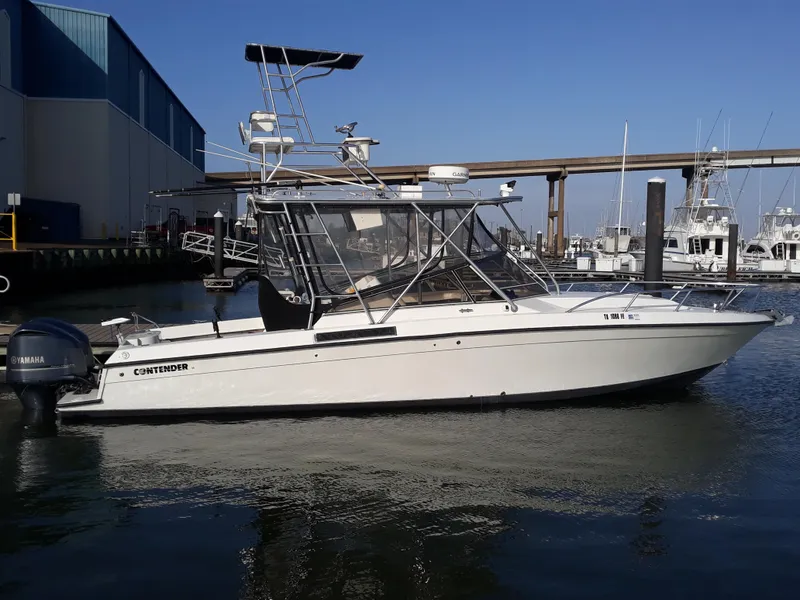 Slide: The Image of 1998 Contender 35 Express Side Console boat docked in marina, clear sky background. - 0