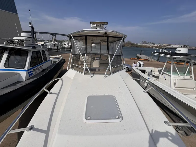 Slide: The Image of 1998 Contender 35 Express Side Console boat docked at marina, front view. - 13
