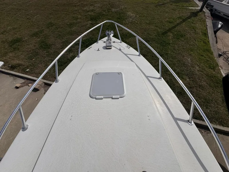 Slide: The Image of Bow view of 1998 Contender 35 Express Side Console boat with railing and hatch. - 14