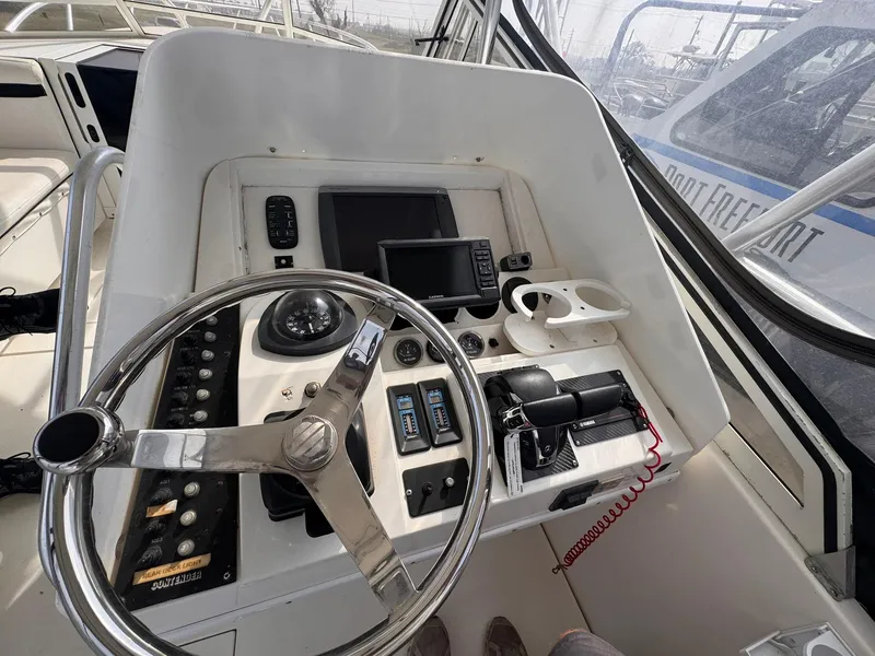 Slide: The Image of 1998 Contender 35 Express Side Console helm with steering wheel, controls, and navigation equipment. - 17