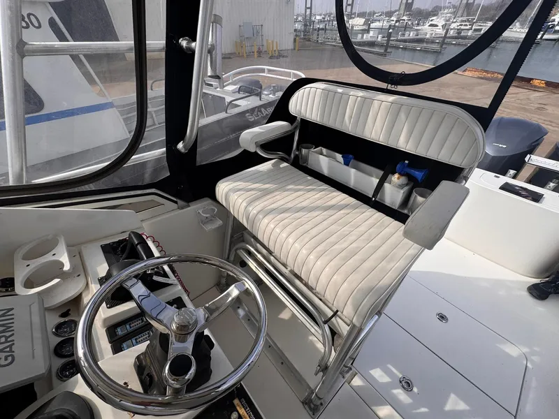 Slide: The Image of 1998 Contender 35 Express Side Console interior with steering wheel and cushioned seating. - 19