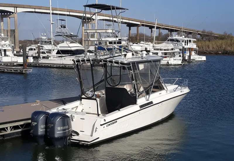Slide: The Image of 1998 Contender 35 Express Side Console boat docked in marina with Yamaha engines. - 2