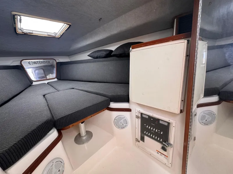 Slide: The Image of 1998 Contender 35 Express Side Console cabin interior with cushioned seating and storage. - 27