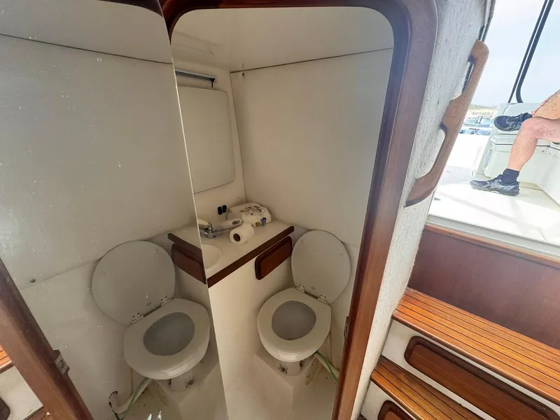Slide: The Image of 1998 Contender 35 Express Side Console boat interior with toilet and wooden steps. - 28