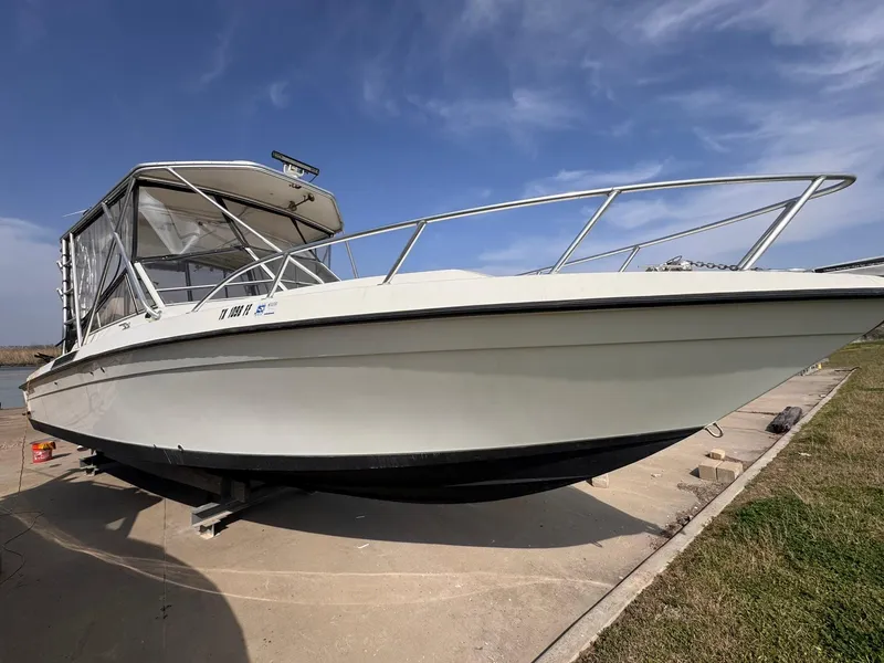 Slide: The Image of 1998 Contender 35 Express Side Console boat on a concrete dock under a clear sky. - 6