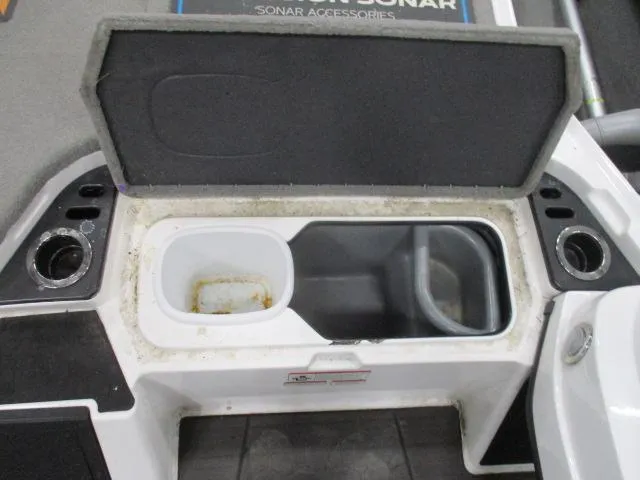 Slide: The Image of 2024 Nitro Z20 boat storage compartment with open lid and cup holders. - 2