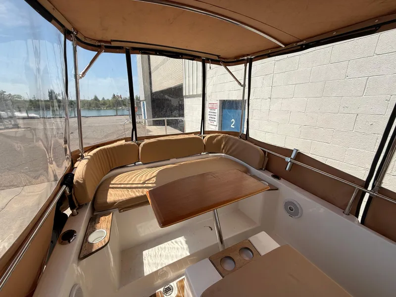 Slide: The Image of 2016 Ranger Tugs R-21 EC interior with seating and table, dockside view. - 15