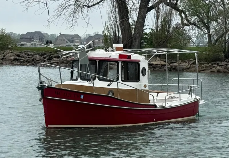 Slide: The Image of 2016 Ranger Tugs R-21 EC boat on calm water near shoreline. - 16