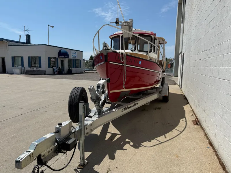 Slide: The Image of 2016 Ranger Tugs R-21 EC boat on trailer, parked outside a service building. - 19