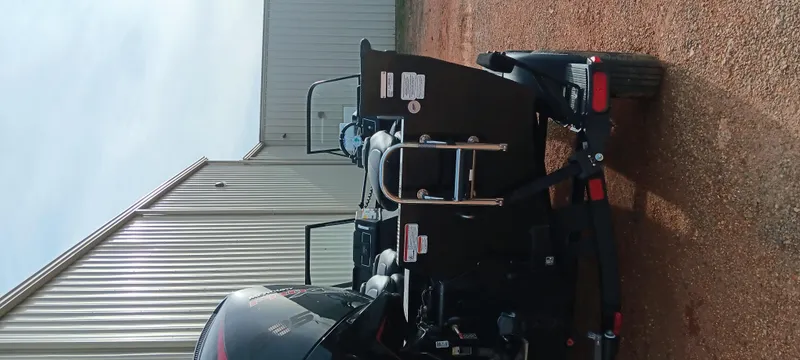 Slide: The Image of 2024 Ranger VX1888 WT boat on trailer, parked near a metal building. - 23