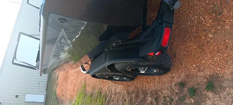 Slide: The Image of 2024 Ranger VX1888 WT boat trailer on gravel, showcasing rear wheels and lights. - 3