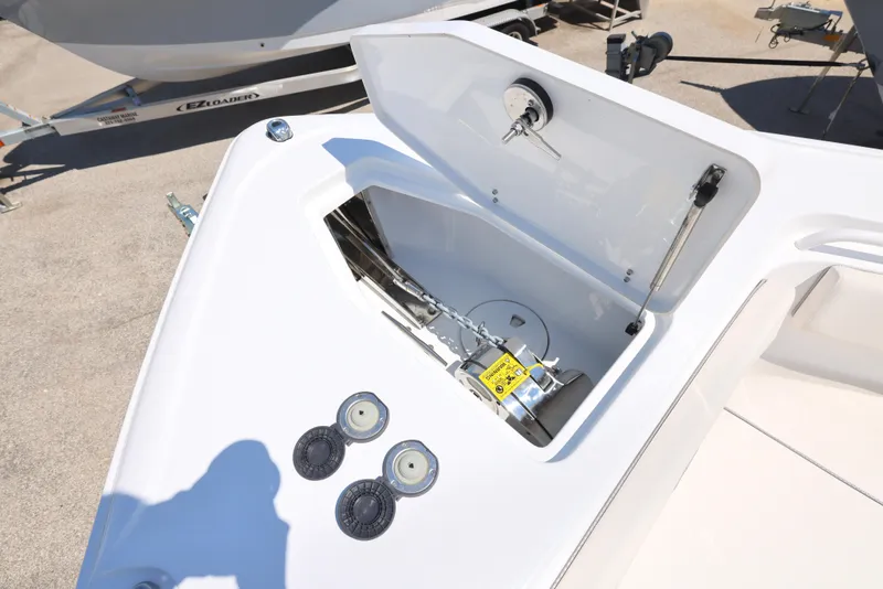 Slide: The Image of 2025 Sea Hunt Ultra 265 SE boat anchor compartment with open lid and visible mechanisms. - 18