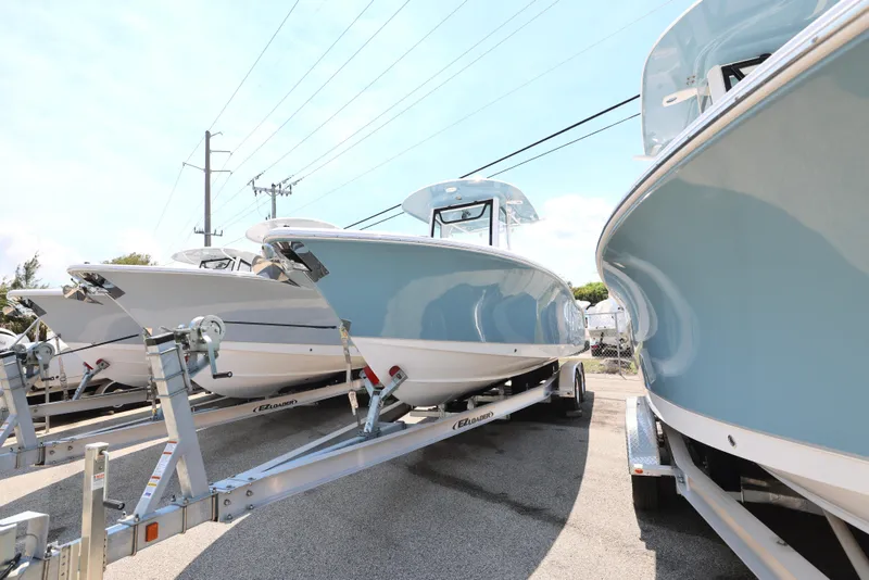 Slide: The Image of 2025 Sea Hunt Ultra 265 SE boats on trailers in a parking lot. - 8